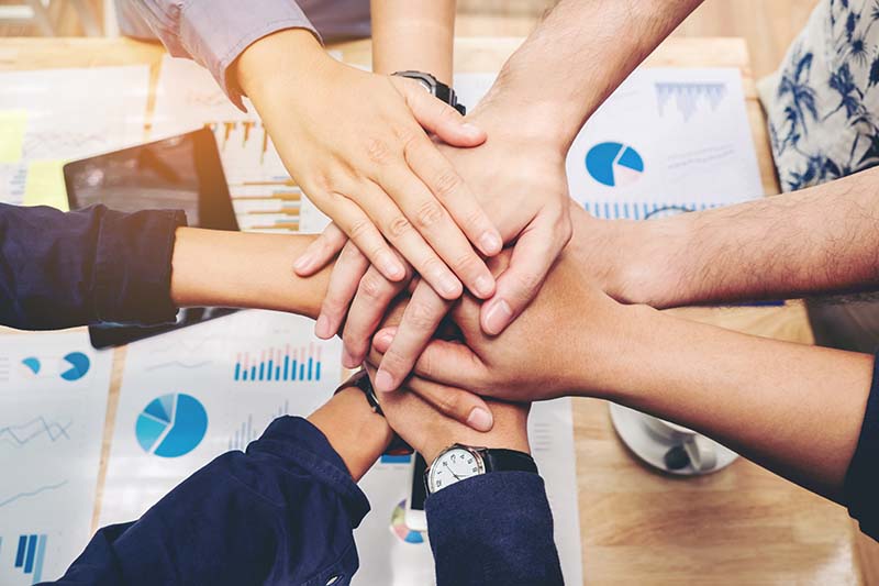Team members joining hands